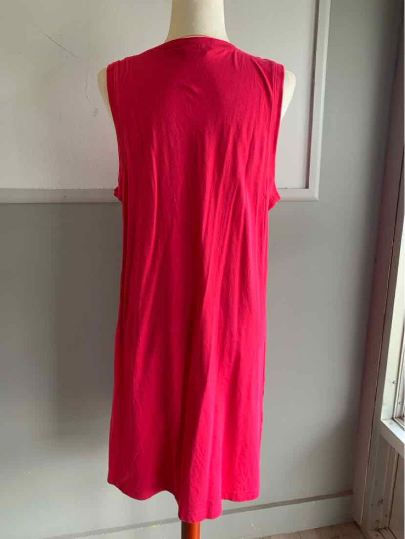 Sleeveless solid pink knee-length dress with a relaxed fit on a mannequin.
