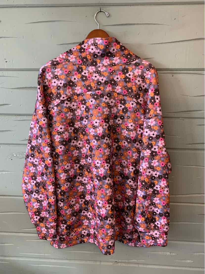 Long-sleeve button-up shirt with vibrant floral pattern in pink, orange, and black colors.
