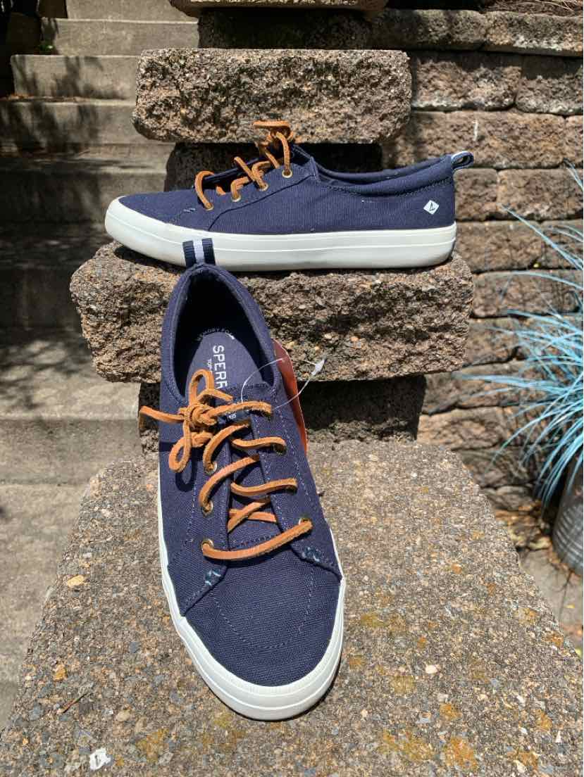 Navy blue canvas Sperry boat shoes with white rubber soles and brown leather laces, size 8.5.