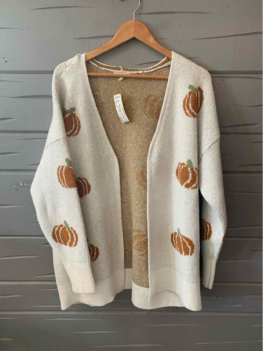Cream knit cardigan with orange pumpkin patterns, open front, and long sleeves.