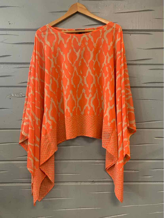 Orange oversized knit sweater with animal print and asymmetrical hem on wooden hanger.