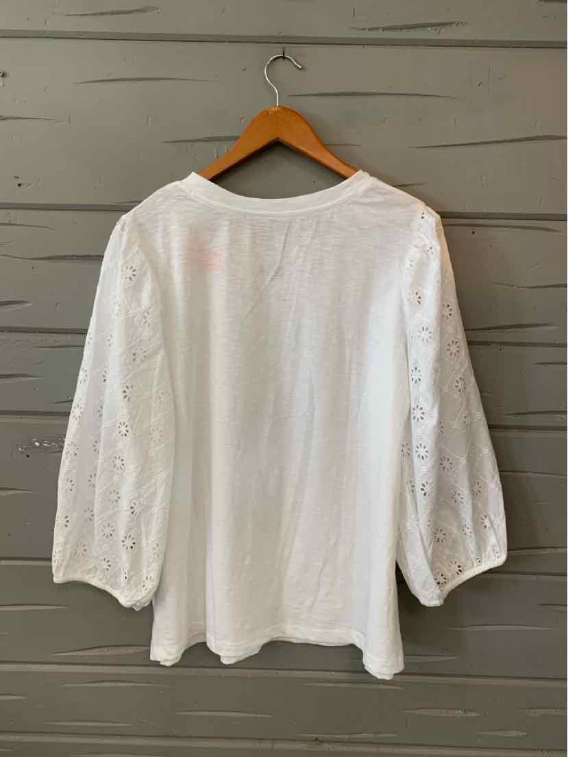 White long-sleeve blouse with puffed sleeves and eyelet lace detailing on sleeves.