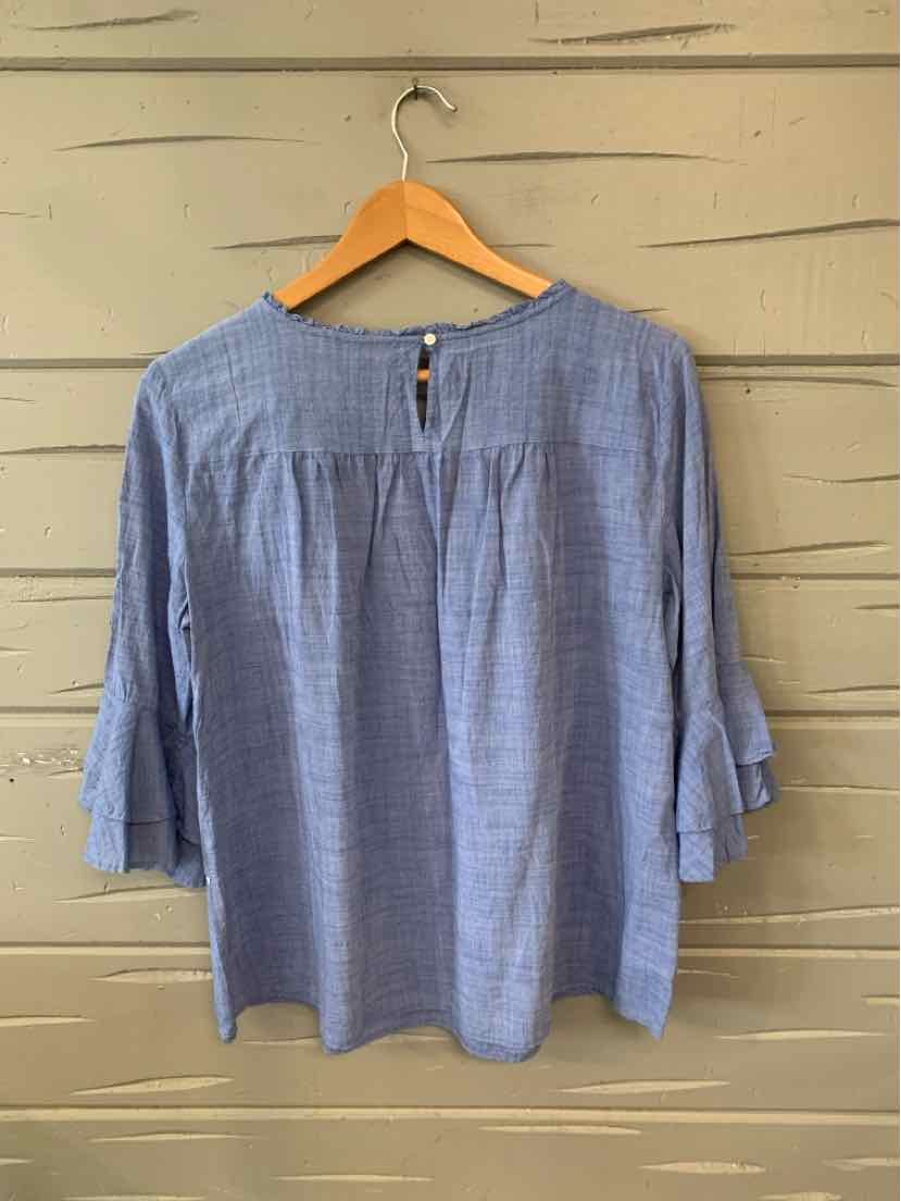Blue lightweight blouse with 3/4 sleeves and button keyhole back detail hanging on wooden hanger.