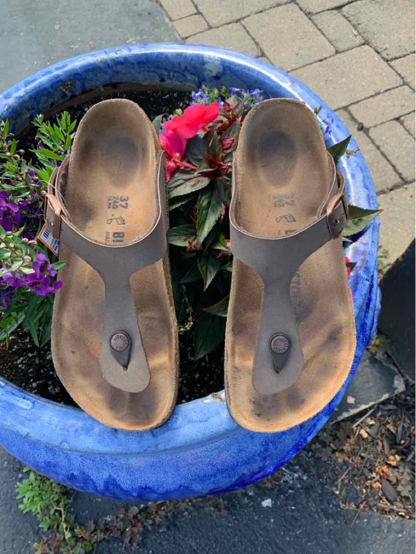 Brown leather Birkenstock sandals with a toe post and contoured footbed, size 37.