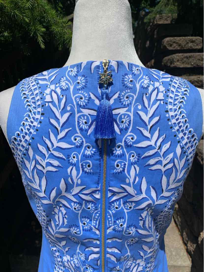 Blue sleeveless dress with white floral embroidery and a back zipper adorned with a blue tassel pull.