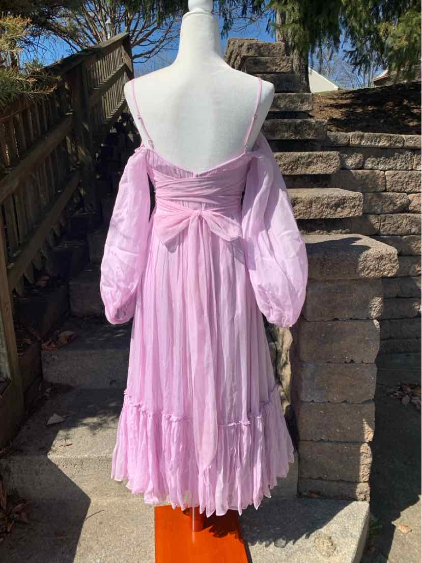 Lavender off-shoulder dress with puffed long sleeves and tiered skirt on mannequin.