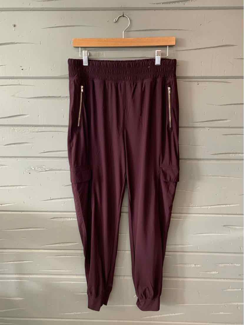 Dark plum jogger pants with elastic waistband, zipper pockets, and cuffed ankles.