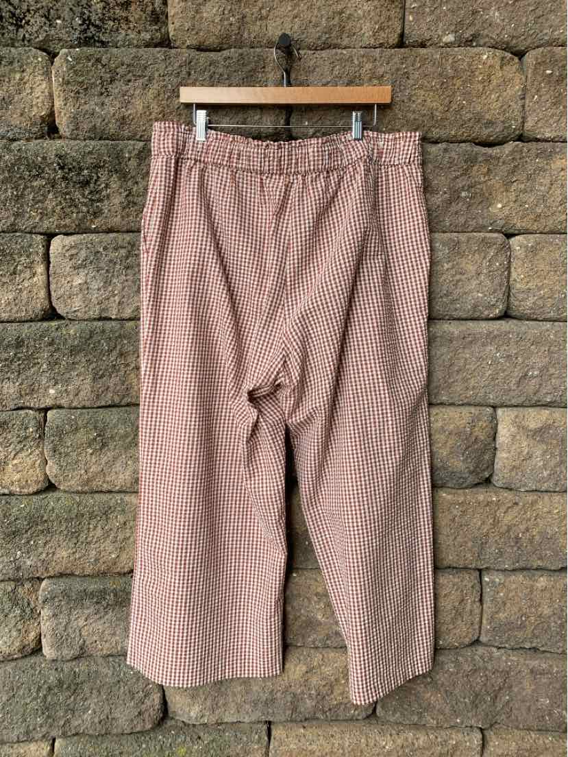 Pink gingham-patterned cropped pants with an elastic waistband and relaxed fit.