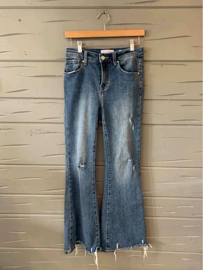 Blue denim jeans with slight distressing, raw frayed hems, and classic five-pocket styling.