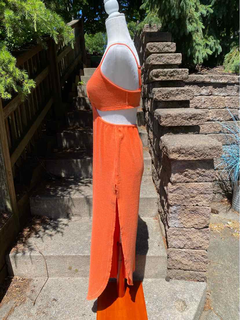 Bright orange sleeveless crop top and matching high-waisted maxi skirt with side slit, lightweight fabric.