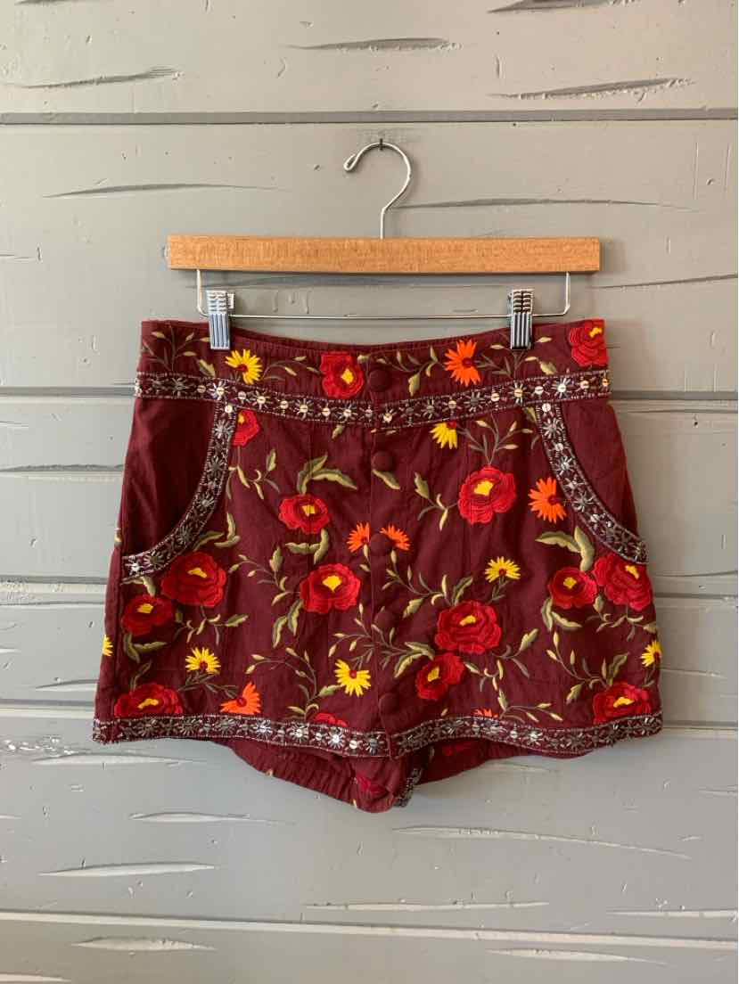 Burgundy floral skort with yellow and red flowers, front pockets, and button details.