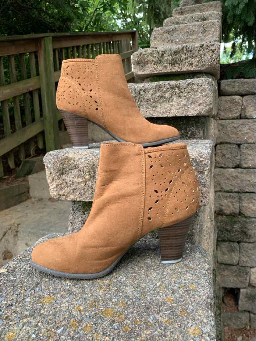 Tan suede ankle boots with stacked wooden heels, perforated side detailing, and pointed toes.