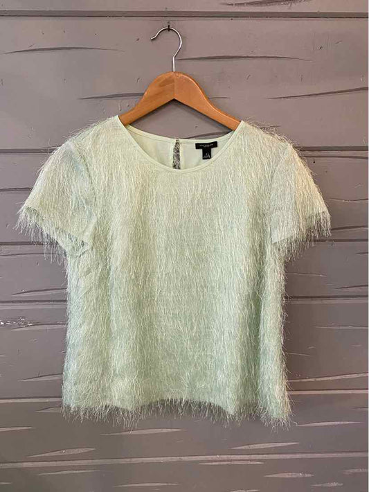 Light green textured short-sleeve blouse with a subtle fuzzy fabric on wooden hanger.