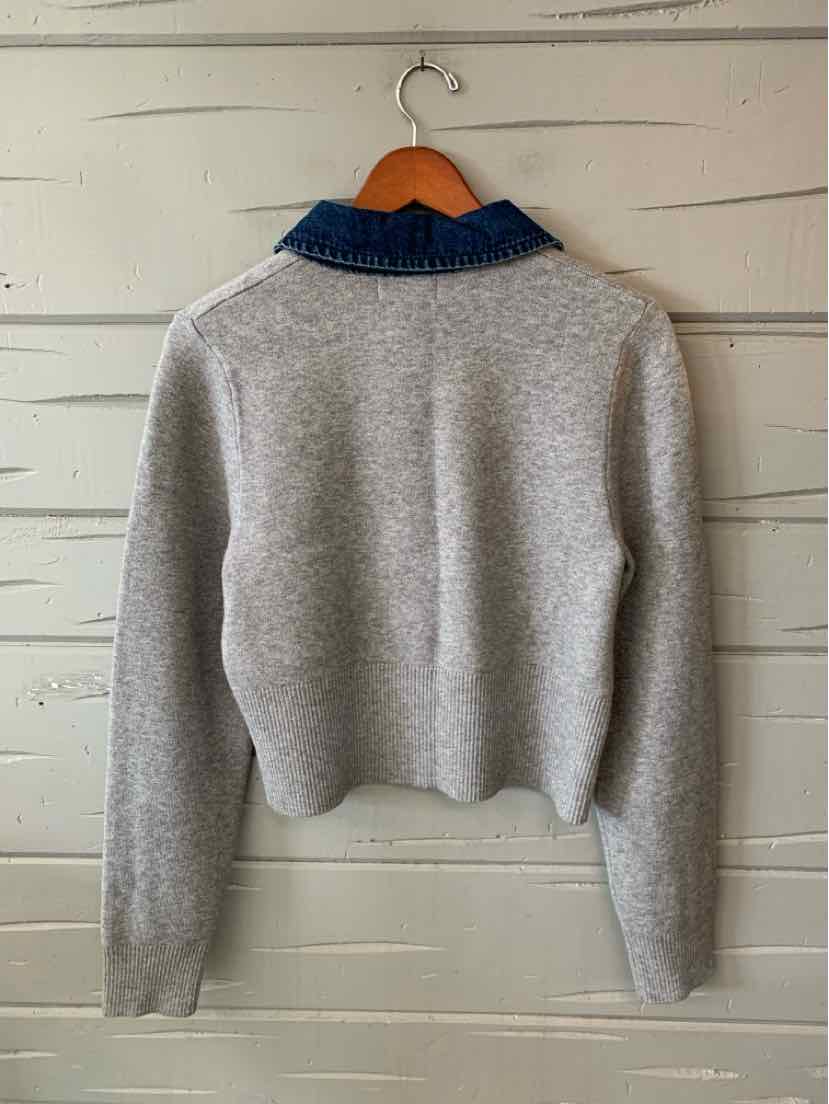Gray knit sweater with long sleeves, a cropped hem, and a navy ribbed collar.