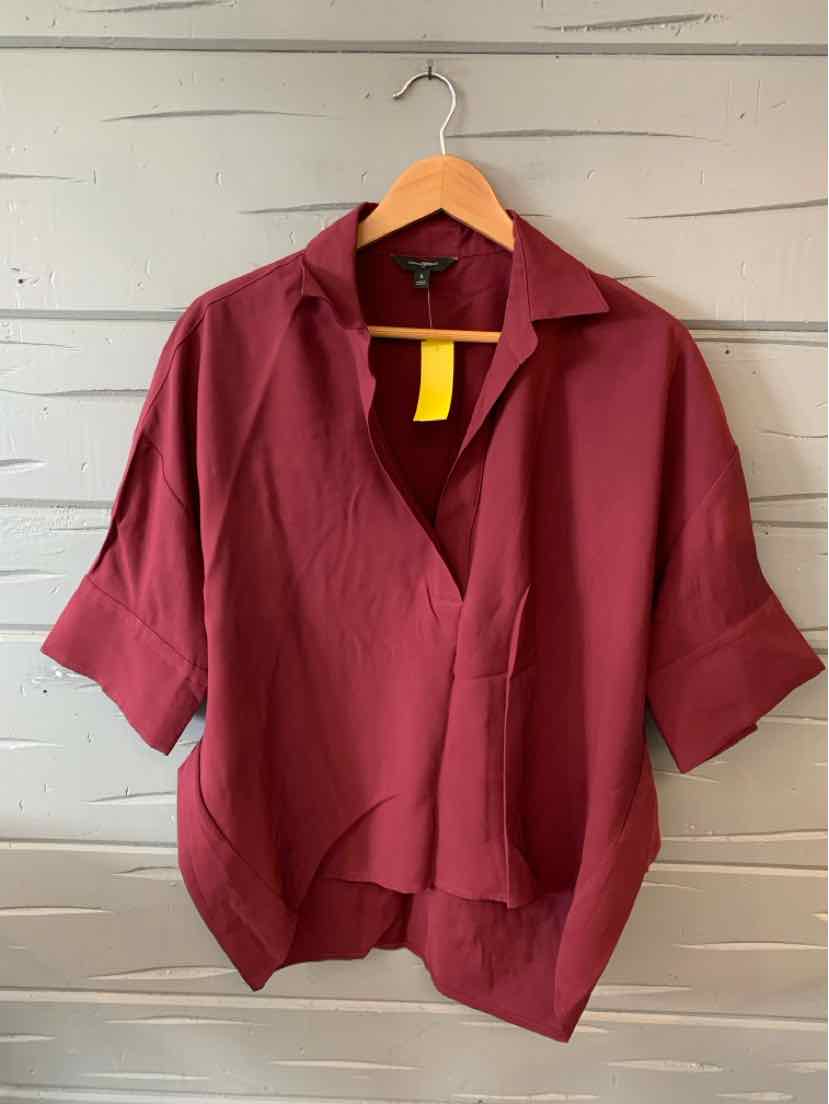Burgundy short-sleeve blouse with a relaxed fit and open collar on wooden hanger.