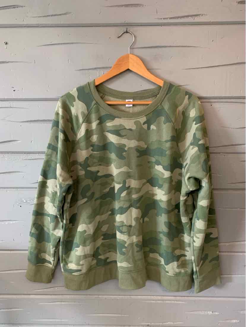 Green and beige camo long-sleeve sweatshirt with ribbed cuffs and hem hanging on wooden hanger.