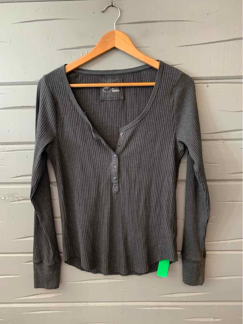 Long-sleeve gray henley shirt with three buttons and fitted cuffs on wooden hanger.