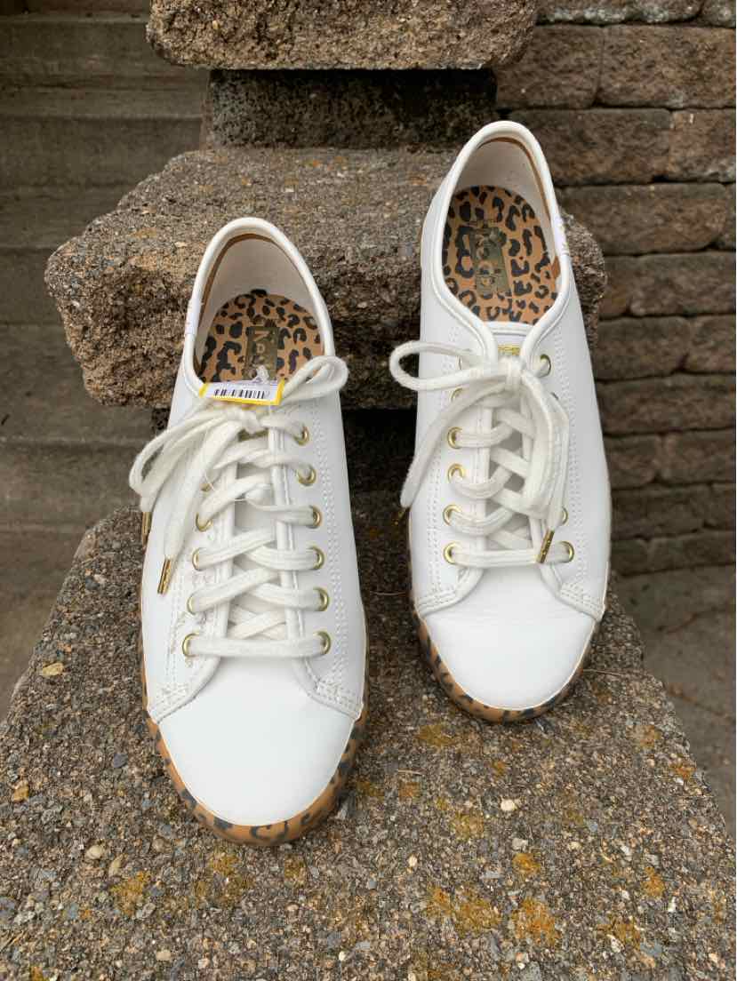 White low-top canvas sneakers with white laces and leopard print insoles, size 8.