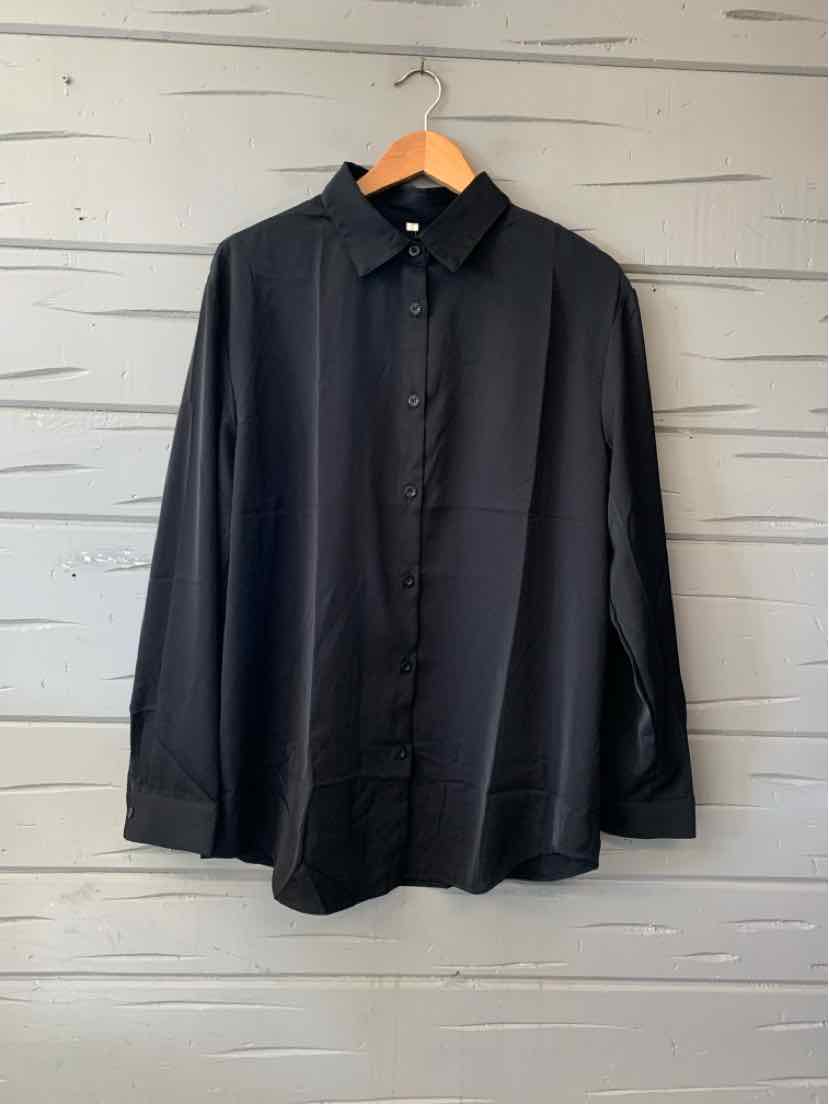 Solid black long-sleeve button-up shirt with a pointed collar and chest pocket, hanging on a wooden hanger.