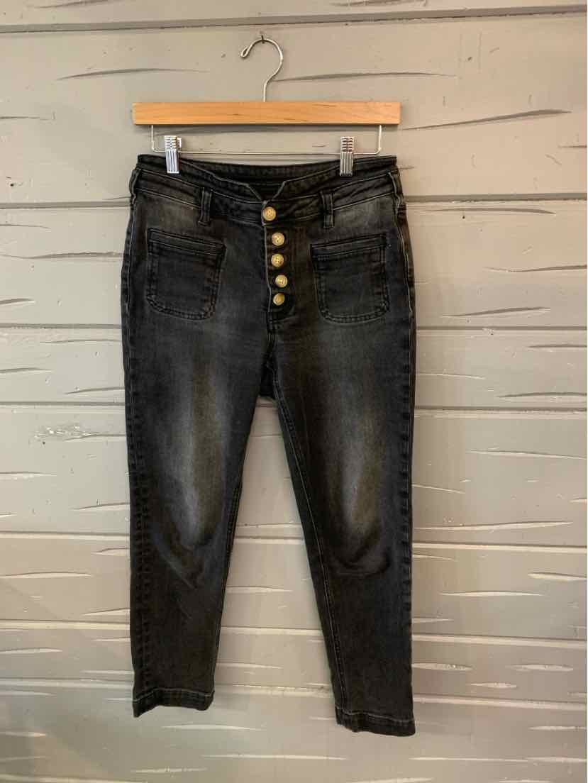 Black high-waisted jeans with four brass buttons and faded detailing on thighs and knees.