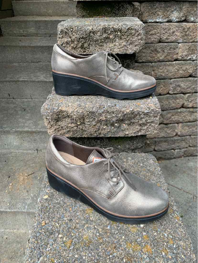 Women's silver leather wedge shoes with lace-up front and black sole, size 10.