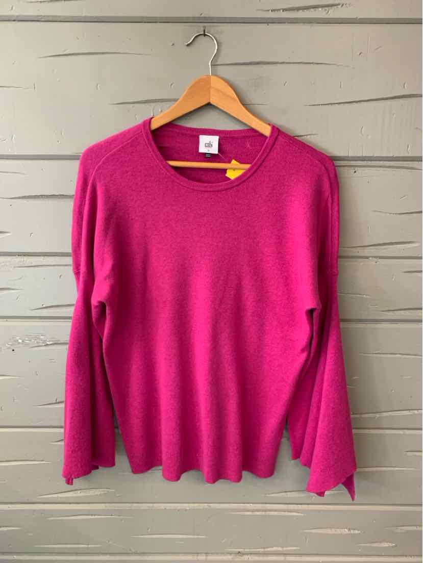 Long-sleeve fuchsia knit sweater with round neckline, soft fabric, and relaxed fit on wooden hanger.