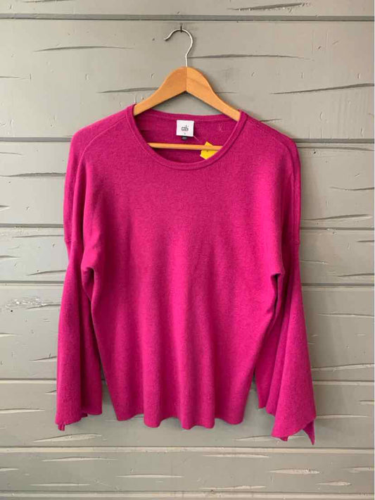 Long-sleeve fuchsia knit sweater with round neckline, soft fabric, and relaxed fit on wooden hanger.