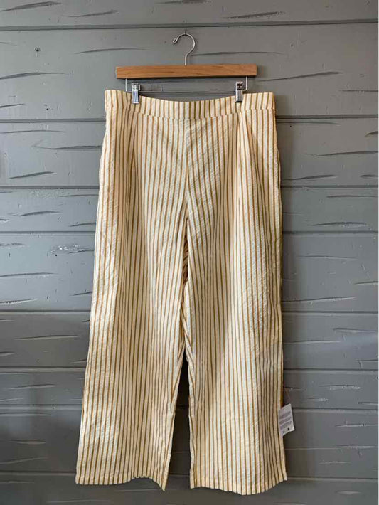 Beige wide-leg pants with vertical white stripes, lightweight fabric, and a relaxed fit.