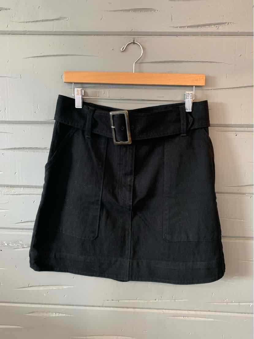 Black high-waisted skirt with front patch pockets and a wide belt with rectangular buckle.