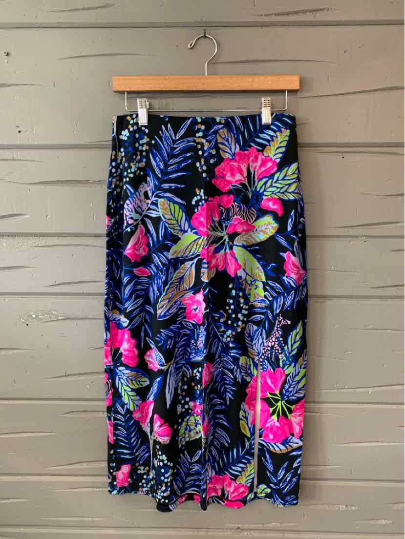 High-waisted tropical print skirt with pink, blue, and green floral pattern on black background, knee-length, lightweight.