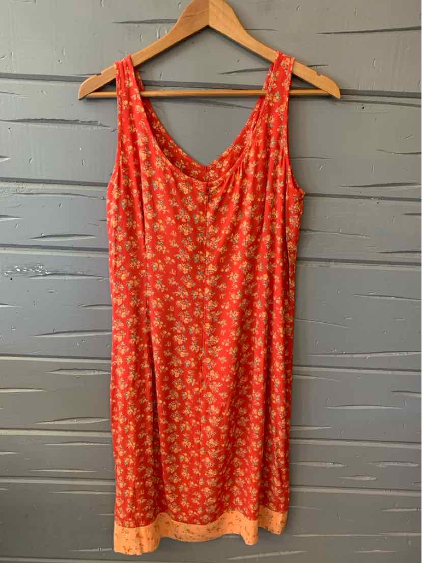 Red sleeveless dress with small floral print and beige trim at the hem, lightweight fabric.