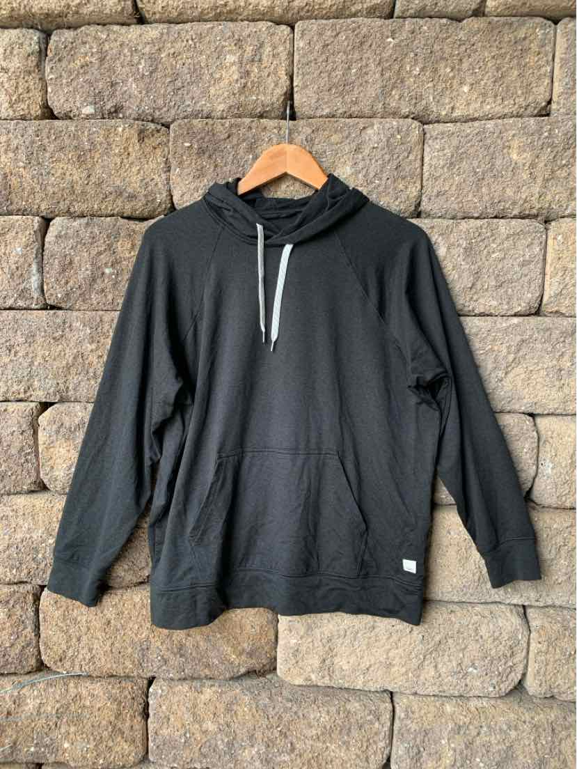 Dark gray pullover hoodie with front kangaroo pocket and white drawstring, hanging on wooden hanger.