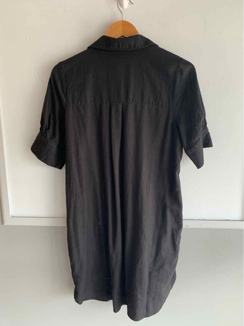 Black short-sleeve collared dress with buttoned sleeve tabs, relaxed fit.