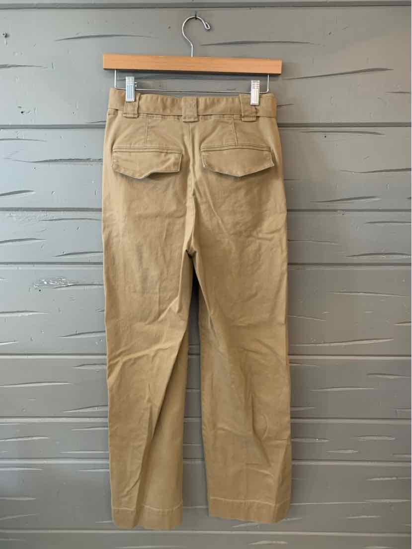 Tan straight-leg pants with back flap pockets and belt loops, hanging on wooden hanger.