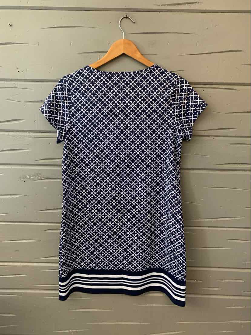 Navy blue short-sleeve dress with white geometric pattern and striped hem hanging on wooden hanger.