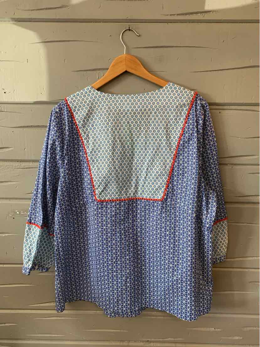 Blue patterned long-sleeve blouse with white polka dot yoke and red piping details.