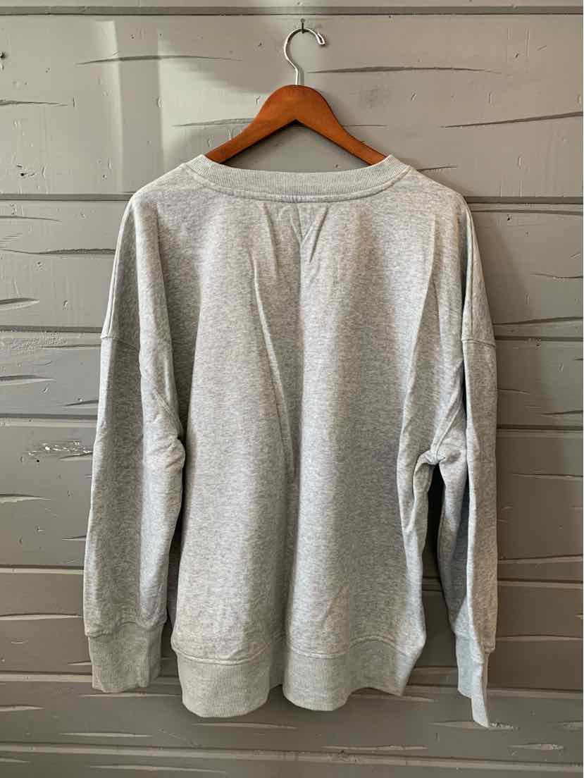 Light gray women’s long-sleeve top with a relaxed fit and subtle ribbed texture, shown from the back.