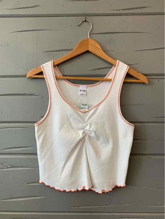 White sleeveless crop top with orange trim, front knot detail, and lettuce edge hem.