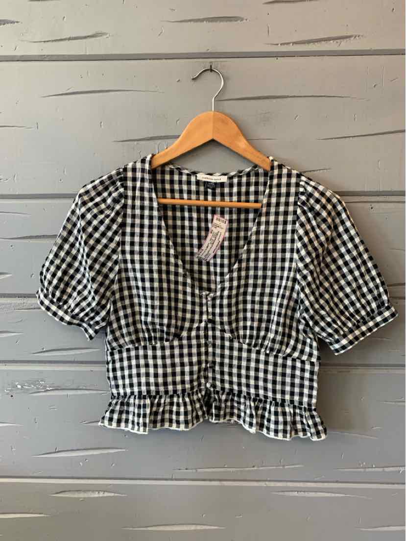 Black and white gingham short-sleeve blouse with v-neck and ruffled hem, size small.
