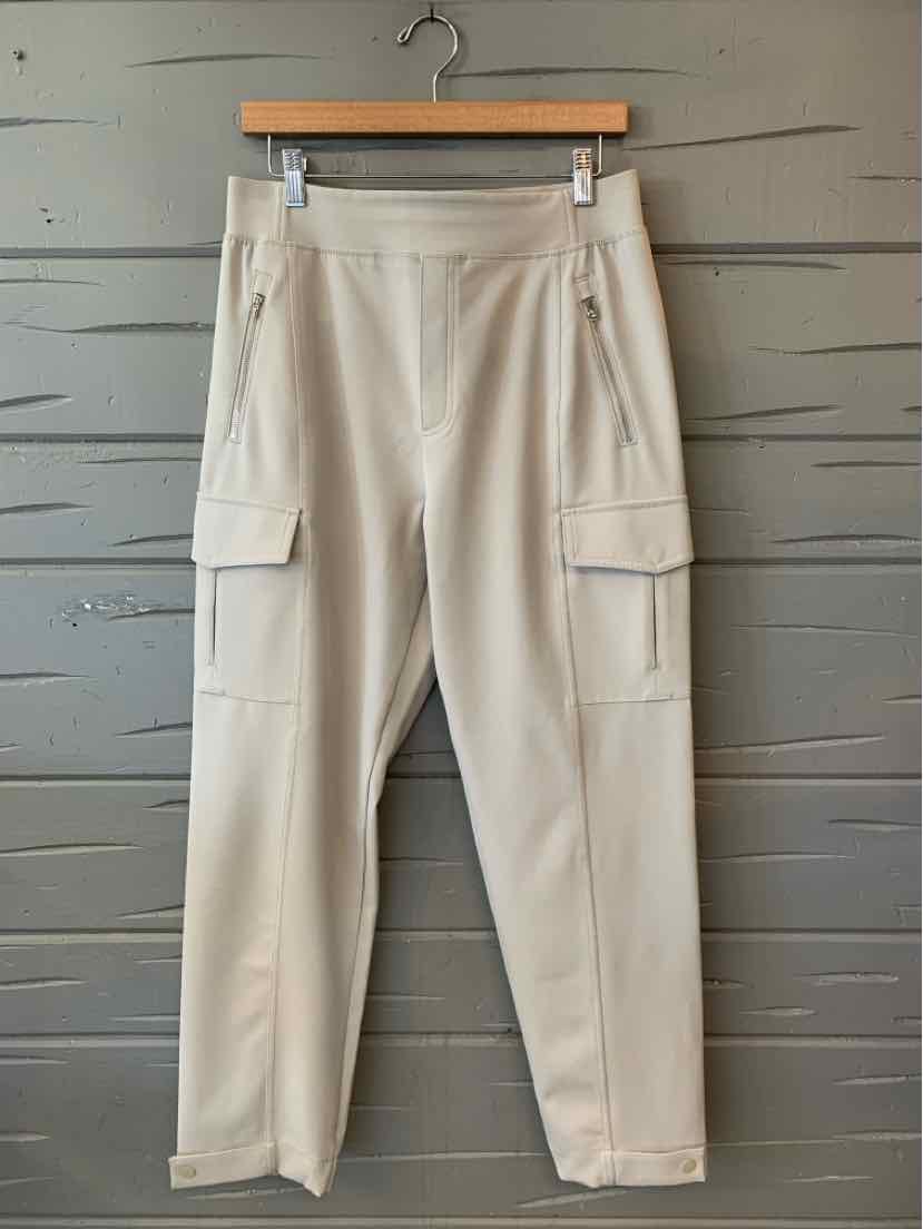 Light beige cargo pants with multiple pockets, tapered legs, and a smooth, stretchy fabric.