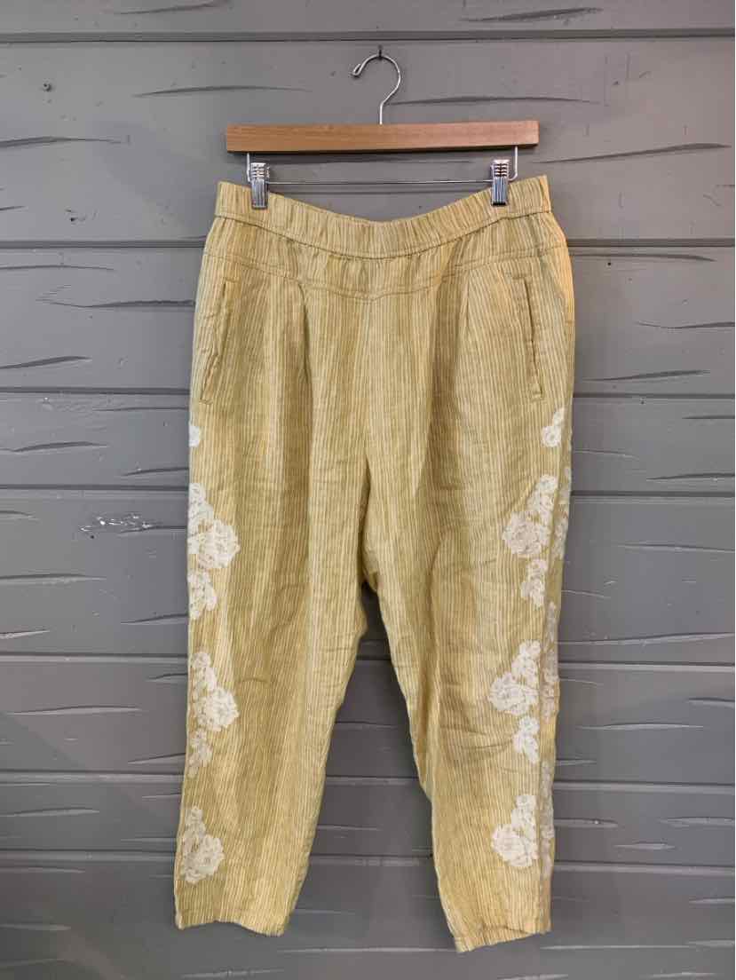 Light yellow linen pants with white floral embroidery on legs and tapered ankles.