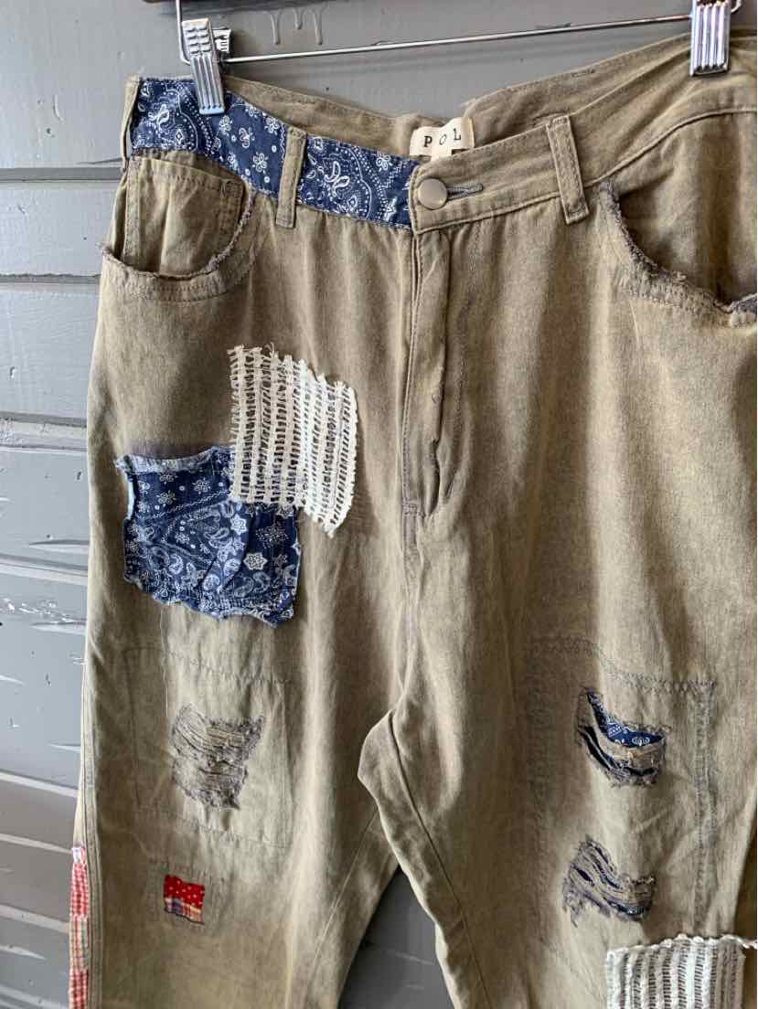 Light brown pants with blue floral and striped patchwork details on pockets and legs, distressed accents.
