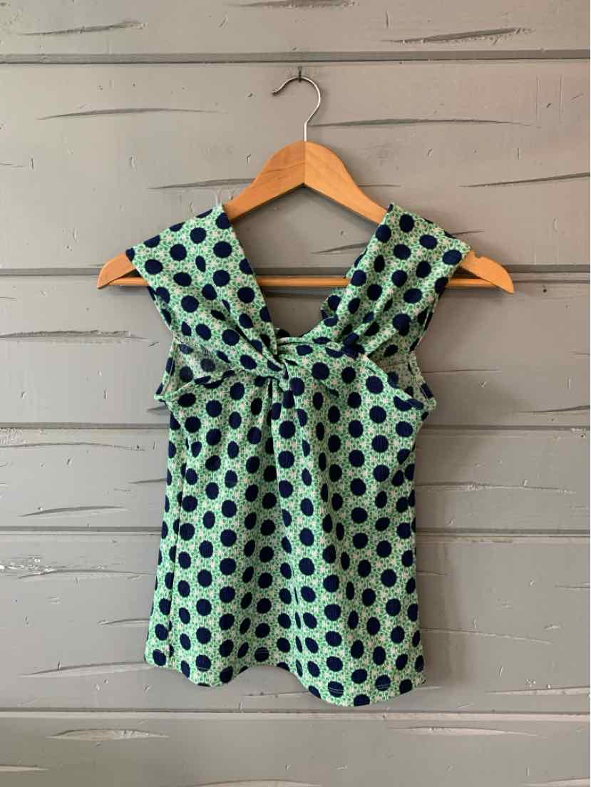 Sleeveless green blouse with large navy polka dots and a twisted front detail.