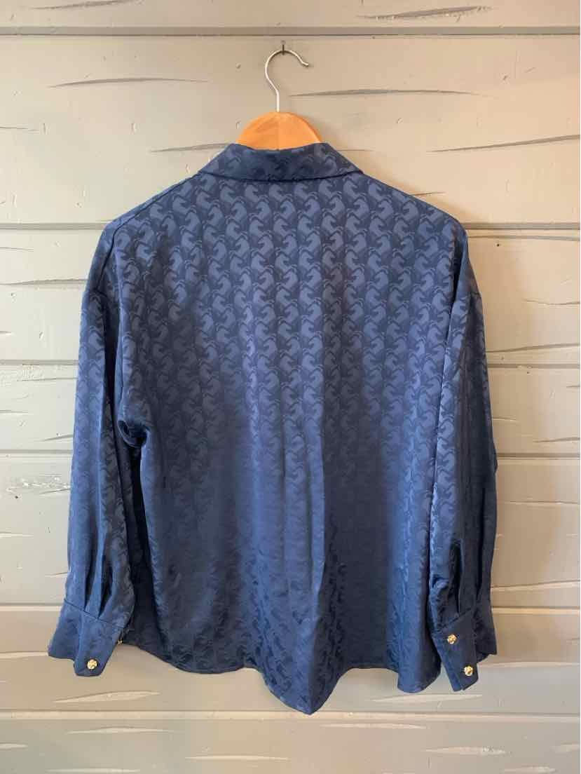 Long-sleeve navy blue shirt with subtle wave pattern, buttoned cuffs, and classic collar hanging on wooden hanger.