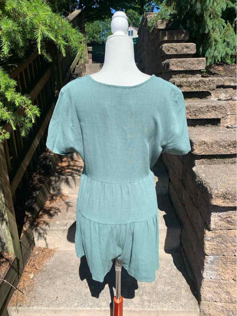 Light green short-sleeve romper with round neckline and fitted waist detail on mannequin outdoors.
