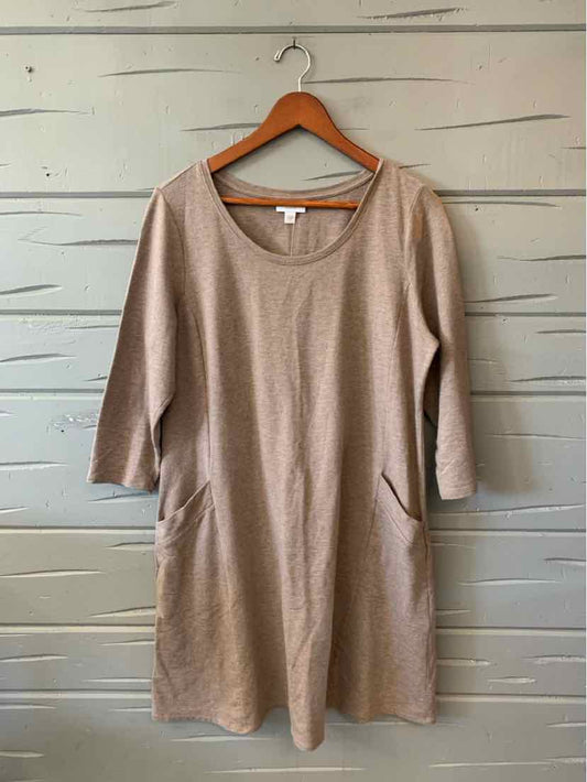 Beige knit women's dress with a scoop neckline, three-quarter sleeves, and side pockets, hanging on a wooden hanger.