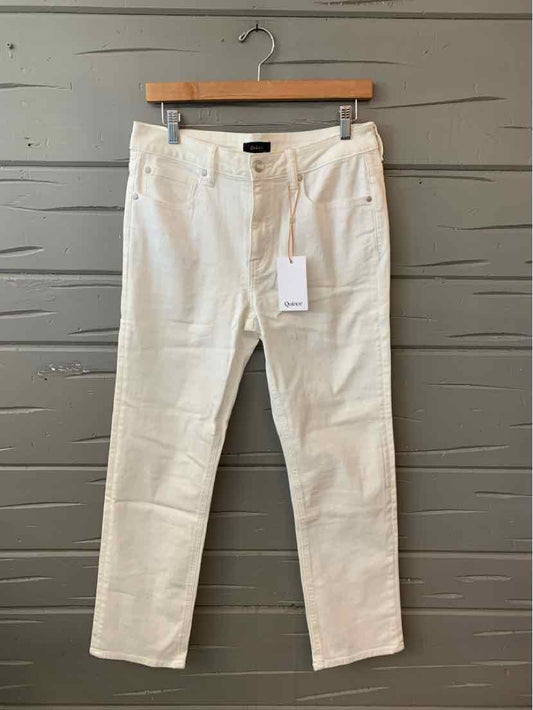 White denim jeans in size 10 with front pockets, belt loops, and a button closure displayed on a wooden hanger against a.