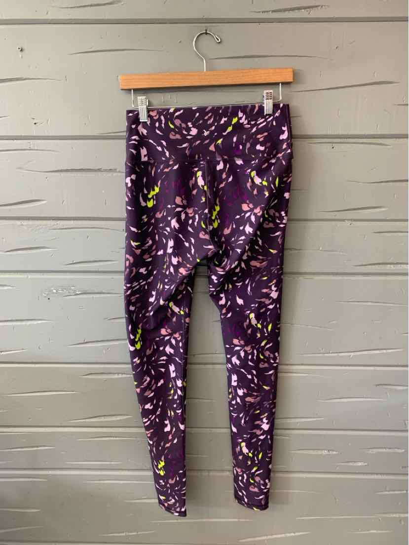 Purple leggings with abstract multicolor floral pattern, mid-rise and slim fit cut.