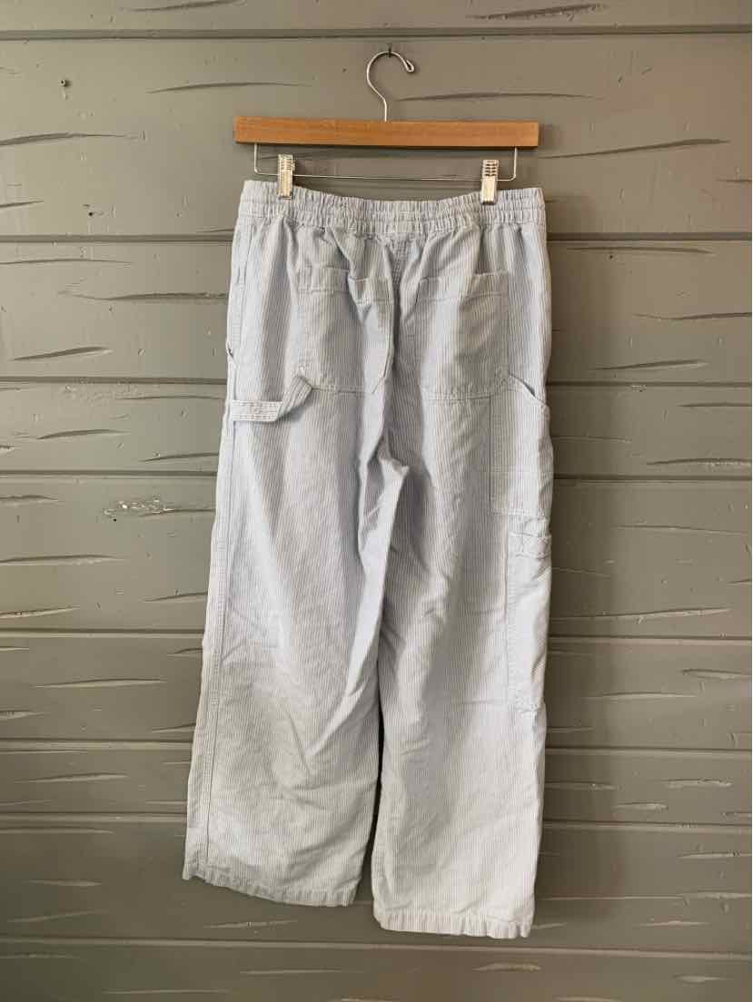 Light blue wide-leg pants with elastic waistband and side pocket hanging on wooden hanger.
