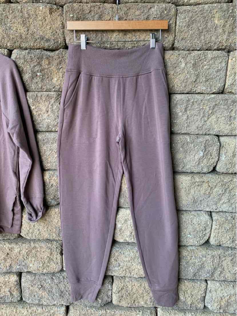 Mauve high-waist jogger pants with elastic waistband and cuffed ankles in soft fabric.